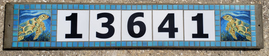 Horizontal glass address sign reading 13641, with a hand-painted sea turtle tile at each end and an iridized blue mosaic border