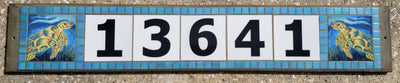 Horizontal glass address sign reading 13641, with a hand-painted sea turtle tile at each end and an iridized blue mosaic border