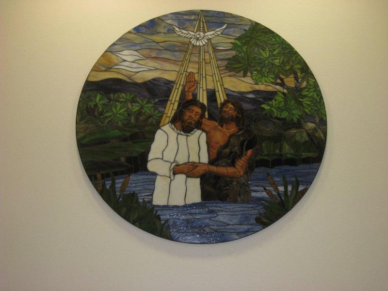 Round stained glass panel of the baptism of Jesus in the River Jordan, by Monica Huber