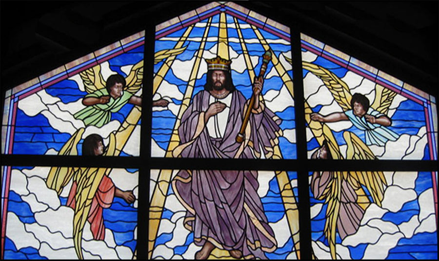 Stained glass church window of Christ the King with angels in blue skies, by Monica Huber